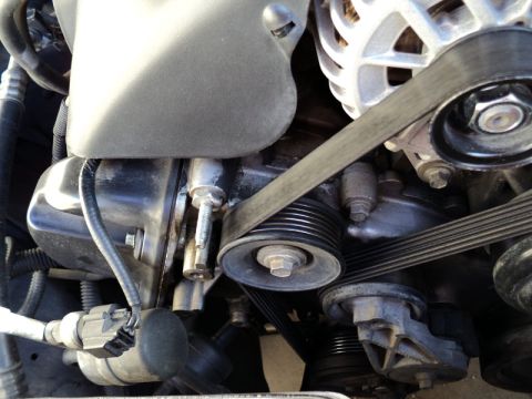 2001 Mercury Grand Marquis - Close-up view of the serpentine belt and pulleys within an engine compartment.