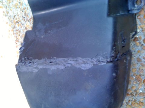 1992 Ford Bronco - This close-up shows a damaged and repaired plastic automotive part, not a 1992 Ford Bronco.