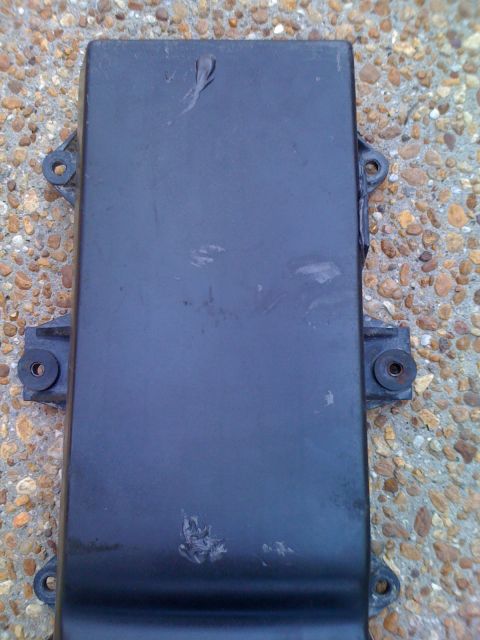 1992 Ford Bronco - A black automotive part with visible mounting hardware is shown from a top-down perspective.