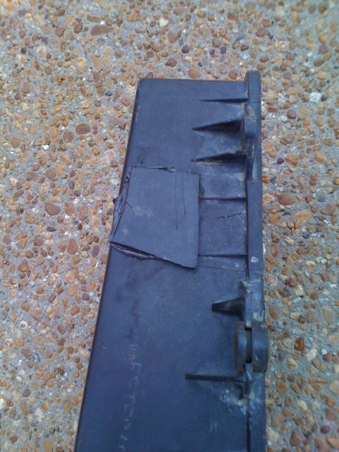 1992 Ford Bronco - A close-up view of a black plastic component, showing signs of repair with tape and some faint text.