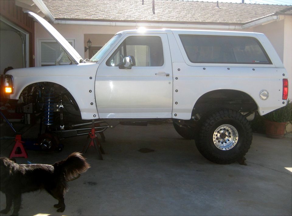 1996 Ford Bronco side view, hood open, front on jack stands, rear tire visible