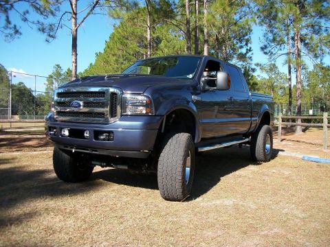 1992 Jeep Cherokee - This lifted Ford F-Series truck has a distinctive grille and large tires, suggesting a model year around 2005.