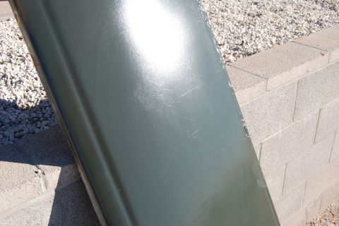 1982 Ford Bronco - Close-up of a green car door panel with visible scratches.