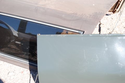 1982 Ford Bronco - A close-up view of a vehicle's door and hood, with visible scratches on the door's surface.
