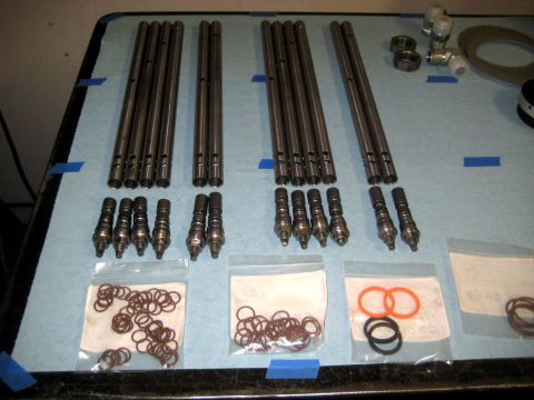 1996 Ford Bronco - Various valve train components are organized on a workbench for inspection or assembly.