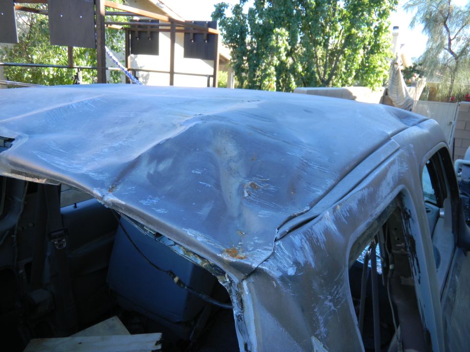Damaged truck roof with significant dents and rust