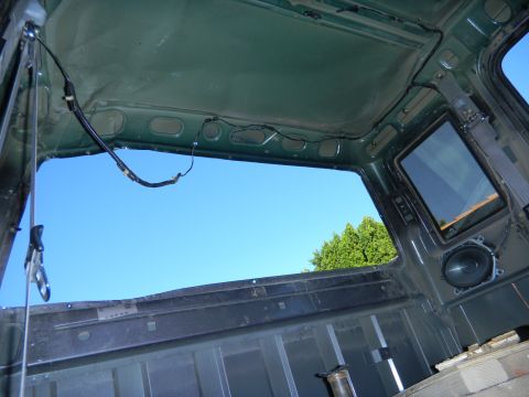1997 Ford Ranger - The interior of a truck cab shows exposed metal and wiring, with a view of the sky through the open roof.