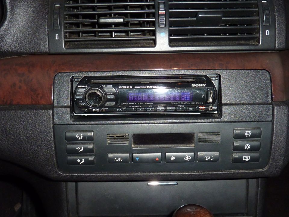 Aftermarket Sony CD receiver installed in a BMW center stack with wood trim