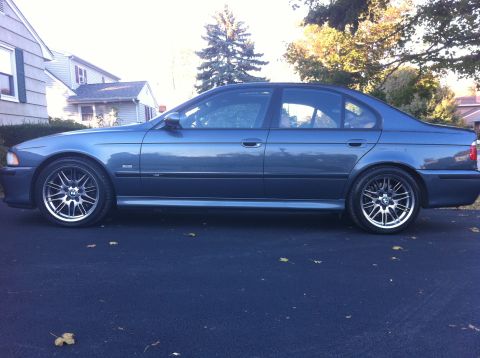 2000 BMW M5 - A blue BMW M5 is parked in front of a house on a paved surface.