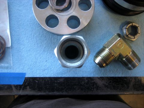 1996 Ford Bronco - Various metal fittings and O-rings are displayed on a blue textured surface.