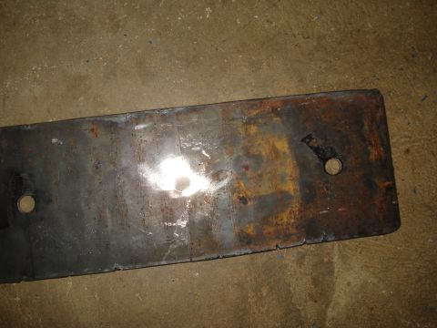1991 Ford Bronco - A rusty metal plate with two holes is shown against a concrete background.