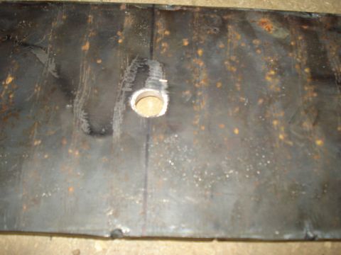 1991 Ford Bronco - A close-up view of a metal plate with a hole drilled through it.