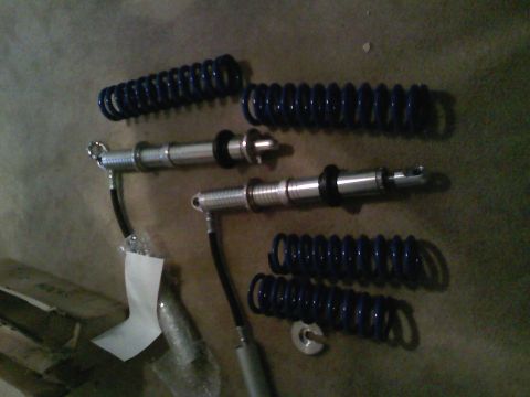 1990 Ford Bronco - Several automotive suspension components, including coil springs and shock absorbers, are laid out on a textured surface.