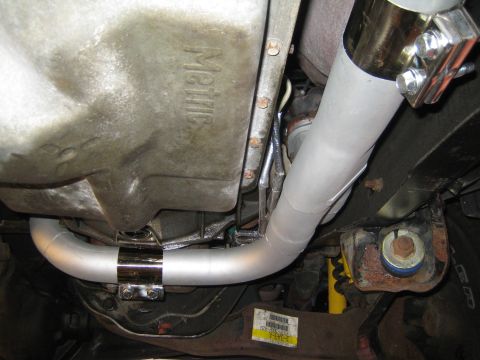 1996 Ford Bronco - Underside view of vehicle exhaust pipe and transmission pan, showing 'Metric' casting.
