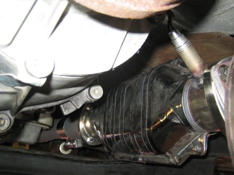 1996 Ford Bronco - Close-up view of a vehicle's exhaust system, showing a catalytic converter and an oxygen sensor.