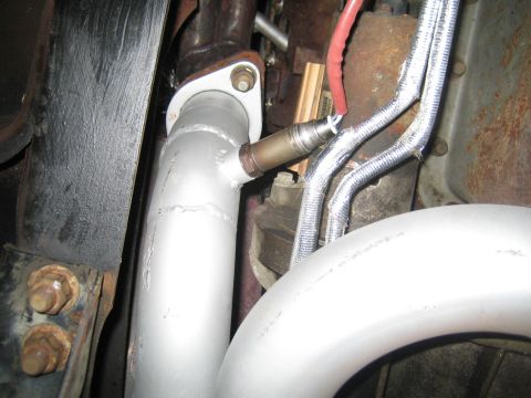 1996 Ford Bronco - Close-up view of an exhaust pipe and oxygen sensor, with some heat-wrapped wiring visible.