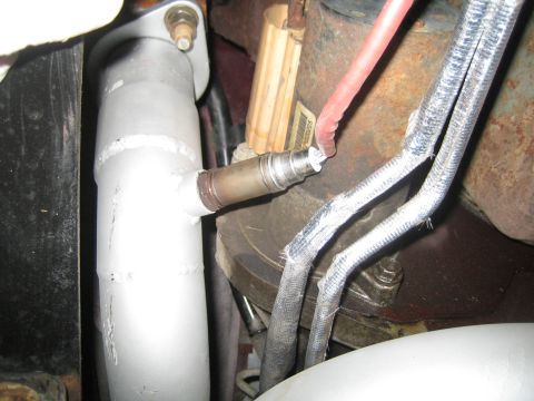 1996 Ford Bronco - Close-up view of an exhaust pipe and oxygen sensor, with associated wiring.