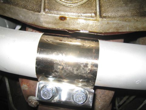 1996 Ford Bronco - Close-up of an exhaust pipe clamp, with oil dripping from the casing above.