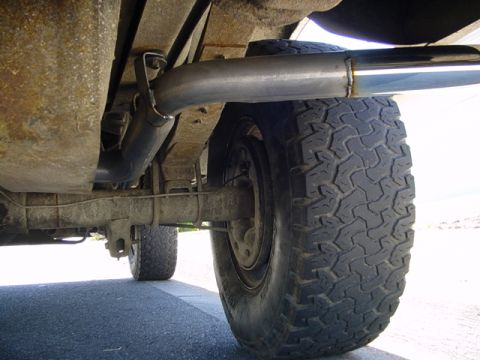 1987 Ford Bronco - Close-up view of the exhaust system and rear axle of a vehicle.