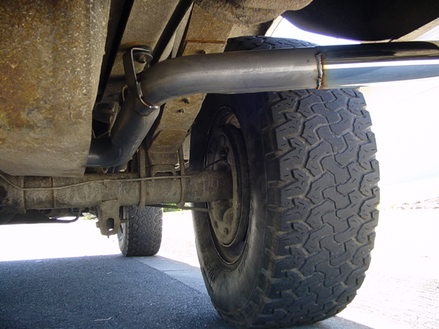 Under-truck view of exhaust pipe with chrome tip exiting ahead of rear tire