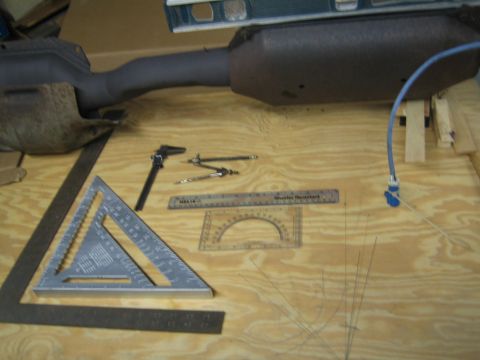 1996 Ford Bronco - Measuring tools and an exhaust pipe section are laid out on a wooden workbench.