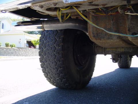 1987 Ford Bronco - Undercarriage view of a 1987 Ford Bronco, highlighting the exhaust system and rear tire.