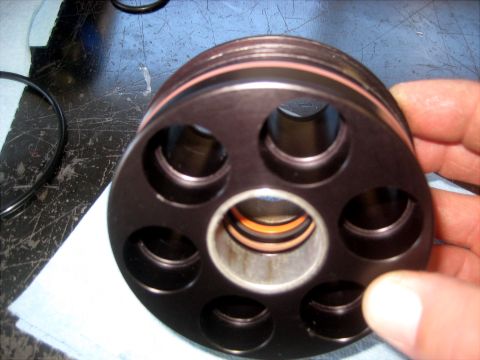 1996 Ford Bronco - A hand holds a disassembled hydraulic pump part, revealing its internal components and seals.