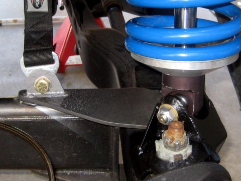 1996 Ford Bronco - Custom suspension part with a blue spring and black strap is bolted to a vehicle's frame.