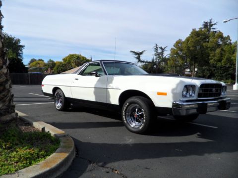 1973 Ford Ranchero - A white Ford Ranchero with a black accent on the hood is parked in an outdoor lot under a partly cloudy sky.