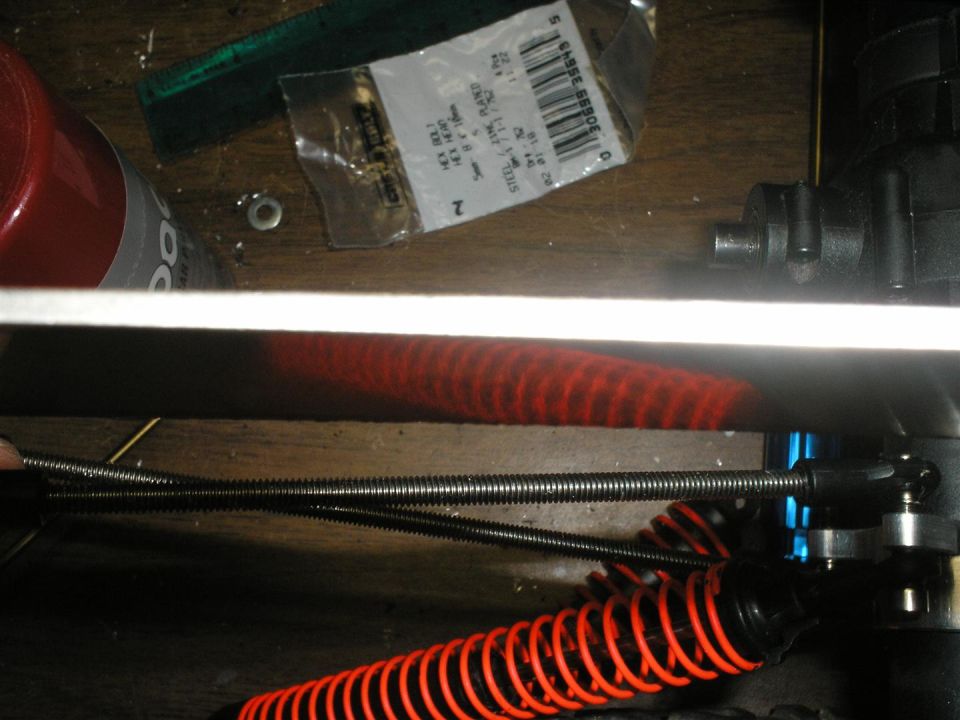 RC car suspension with red springs and metal rods