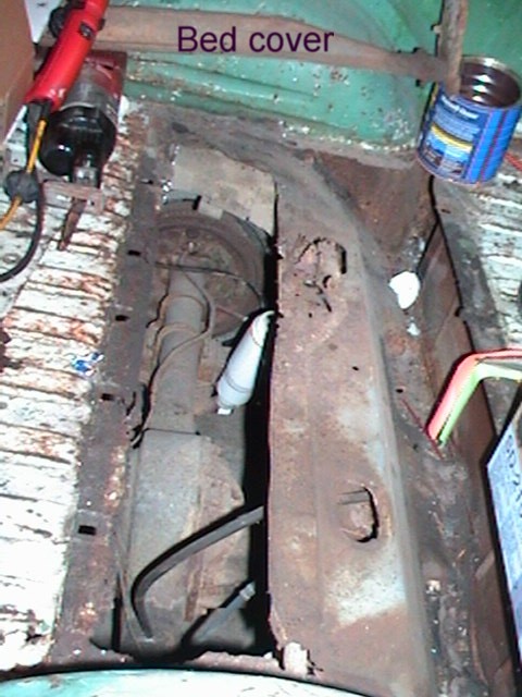 1971 Ford Ranchero - The interior of a vehicle bed shows significant rust and exposed mechanical parts.
