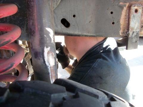 1969 Ford F-250 - Mechanic performing maintenance on the suspension system of an unidentified vehicle.