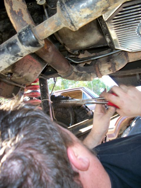 1969 Ford F-250 - Working on the underside of a vehicle, with another truck in the background.