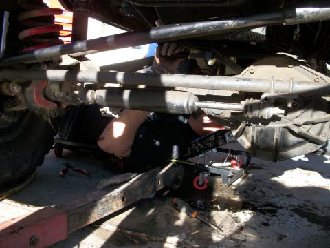 1969 Ford F-250 - A mechanic works on the underside of a vehicle, with tools and equipment visible.