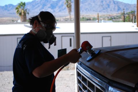 1982 Ford Bronco - A person sands the hood of a 1980 Ford Bronco, preparing it for paint.