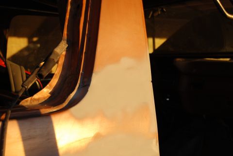 1982 Ford Bronco - Close-up of an interior panel undergoing repair, with primer and tape visible.