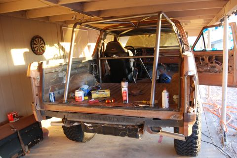 1982 Ford Bronco - Custom roll cage installed in a pickup truck bed, showing interior and bed contents.