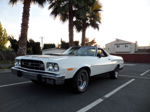 1973 Ford Ranchero - A white 1972 Ford Ranchero is parked in a lot with palm trees in the background.