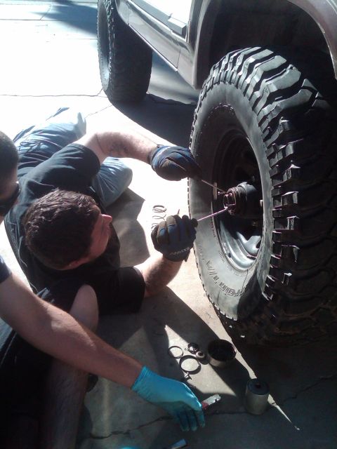 1982 Ford Bronco - Mechanics are shown performing maintenance on a vehicle's wheel hub assembly.