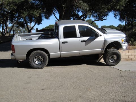 2006 Dodge 2500 - Silver 2006 Dodge 2500 pickup truck with a lifted suspension is parked on a paved surface.