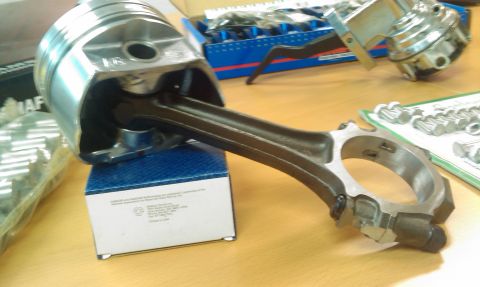 1973 Ford Ranchero - Engine piston and connecting rod assembly, likely for a Ford 400 engine, with other parts on a table.