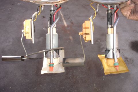 1990 Ford Taurus - Two fuel pump assemblies are shown, each with a yellow filter sock and orange connector, against a dark background.