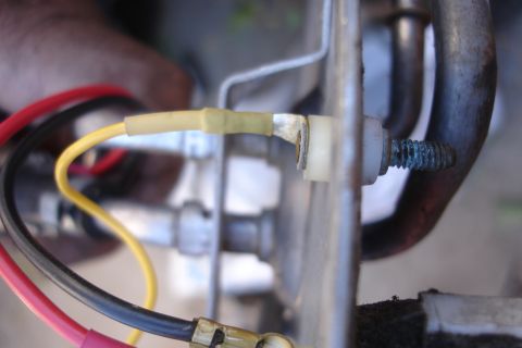 1990 Ford Taurus - A close-up view shows a corroded bolt and a yellow electrical connector attached to a vehicle's fuel pump.