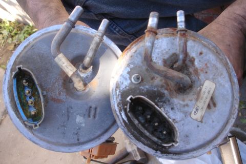 1990 Ford Taurus - Two fuel pump assemblies are shown, one with a visible Ford label and part number, indicating they are automotive parts.