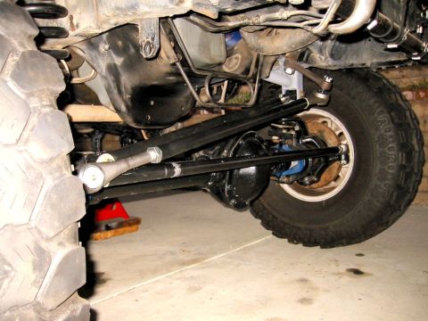 1985 Ford Bronco - Undercarriage view of a modified off-road vehicle's front suspension and drivetrain components.