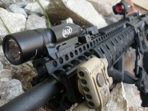 1996 Ford Bronco - A close-up view of an AR-15 rifle's handguard, mounted tactical accessories.