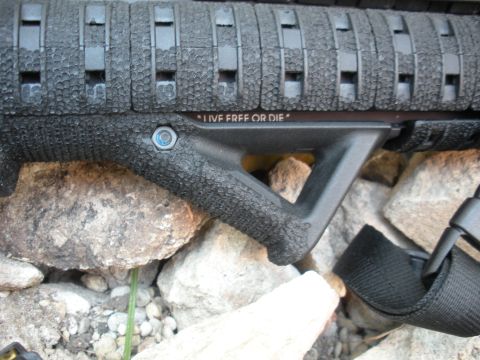 1996 Ford Bronco - A firearm foregrip with engraved text is shown against a rocky background.