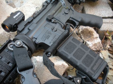 1996 Ford Bronco - Close-up view of an AR-15 rifle, an Aimpoint optic and a loaded magazine.