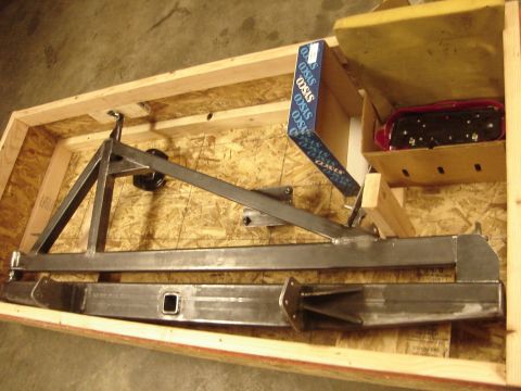1989 Ford Bronco - Custom rear bumper assembly and a red taillight are packed in a wooden crate.