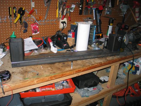1984 Ford Bronco - A workbench is cluttered with tools, supplies, and a metal fabrication project in progress.